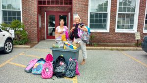 Photo of principal and teacher with donated school supplies