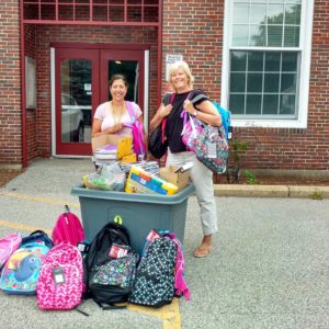 Photo of principal and teacher with donated school supplies